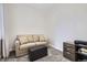 Cozy sitting room with neutral tones and a comfortable couch and ottoman for work or relaxation at 4346 S Quail St, Littleton, CO 80127