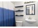 Cozy bathroom features vanity sink, toilet, and a blue and white shower curtain at 1310 N Corona St # A, Denver, CO 80218