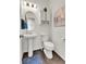 This bathroom features a pedestal sink, an oval mirror, brown wood look flooring, and neutral paint at 240 S Oak Hill St, Aurora, CO 80018