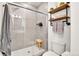 Tiled bathroom featuring walk-in shower, glass enclosure, and rustic wooden shelves at 240 S Oak Hill St, Aurora, CO 80018