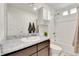 Bathroom featuring a granite-look countertop, white cabinets, and tiled shower and tub at 240 S Oak Hill St, Aurora, CO 80018