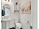 Stylish powder room with pedestal sink, modern toilet, and decorative artwork at 240 S Oak Hill St, Aurora, CO 80018