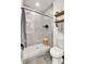 Tiled bathroom featuring walk-in shower, glass enclosure, and rustic wooden shelves at 240 S Oak Hill St, Aurora, CO 80018