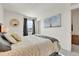 Bright bedroom with cozy bedding, a decorative mirror, neutral paint, and a tree painting at 240 S Oak Hill St, Aurora, CO 80018