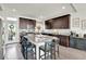 Stylish kitchen with dark wood cabinets, a granite island with seating, and stainless steel appliances at 240 S Oak Hill St, Aurora, CO 80018