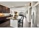 Modern kitchen features granite counters, dark cabinets, wood floors, and opens to the living room at 240 S Oak Hill St, Aurora, CO 80018