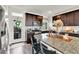 Updated kitchen with granite countertop island, dark cabinets, stainless steel appliances, and white subway tile backsplash at 240 S Oak Hill St, Aurora, CO 80018