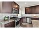 Modern kitchen with stainless steel appliances, granite countertops, and dark wood cabinets for a sleek design at 240 S Oak Hill St, Aurora, CO 80018