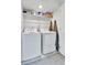 Laundry room featuring tile flooring and a side-by-side washer and dryer with overhead shelving at 240 S Oak Hill St, Aurora, CO 80018