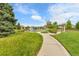 Community playground with lush landscaping, mature trees, and walking path on a bright sunny day at 240 S Oak Hill St, Aurora, CO 80018
