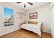 A cozy bedroom with a large window, hardwood floors, and closet at 6606 S Reed Way # B, Littleton, CO 80123