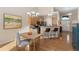 Bright dining area adjoining kitchen with modern lighting and hardwood floors at 6606 S Reed Way # B, Littleton, CO 80123