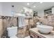 Bathroom featuring a vessel sink and tiled walls with mosaic accents with a toilet on the side at 7640 S Monaco W Cir, Centennial, CO 80112