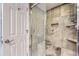 Close-up of a tiled shower with glass doors, built-in niches, and modern fixtures at 7640 S Monaco W Cir, Centennial, CO 80112