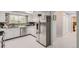 Bright kitchen with stainless steel refrigerator, white cabinets, updated countertops and access to the dining area at 7640 S Monaco W Cir, Centennial, CO 80112