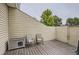 Enclosed wooden deck features wood siding with two chairs and dog house at 7640 S Monaco W Cir, Centennial, CO 80112