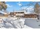 Large backyard with snow, a deck, and partial home view at 995 S Upham St, Lakewood, CO 80226