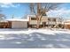 House exterior with a snow-covered yard and attached garage at 995 S Upham St, Lakewood, CO 80226