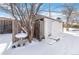 Detached garage with snow-covered ground and wooden fence at 995 S Upham St, Lakewood, CO 80226