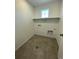 Laundry room with built-in shelving and tile flooring at 191 Freemont Ct, Brighton, CO 80601