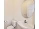 Small bathroom with toilet, sink, and oval mirror at 10767 Mountshire Cir, Highlands Ranch, CO 80126