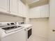 Bright laundry room, featuring white cabinets and modern washer and dryer at 10767 Mountshire Cir, Highlands Ranch, CO 80126