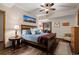 Comfortable bedroom with wooden furniture, ceiling fan, and mountain art for a cozy and inviting space at 8140 Lightening View Dr, Parker, CO 80134