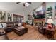 Comfortable living room with a brick fireplace, TV, leather seating, and natural light from the skylight at 8140 Lightening View Dr, Parker, CO 80134