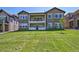 Spacious backyard with lush lawn and a view of the home's stone exterior and balconies at 12121 Bryant St, Westminster, CO 80234