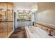 A spacious bathroom with a soaking tub, glass shower, double vanity and a decorative chandelier at 12121 Bryant St, Westminster, CO 80234