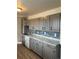 Traditional kitchen with grey cabinets, stainless steel sink, grey backsplash, and white countertops at 7620 Kearney Dr, Commerce City, CO 80022