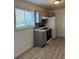 Kitchen with gas range stove, white refrigerator, grey cabinets, and wood floors at 7620 Kearney Dr, Commerce City, CO 80022