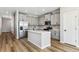 Modern kitchen with stainless steel appliances, a center island, light grey cabinets, and hardwood floors at 9465 Yampa St, Commerce City, CO 80022