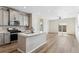 Open-concept kitchen and living space featuring hardwood floors, light grey cabinets, and stainless appliances at 9465 Yampa St, Commerce City, CO 80022