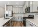 Bright kitchen featuring stainless steel appliances, light grey cabinets, tile backsplash, and hardwood floors at 9465 Yampa St, Commerce City, CO 80022