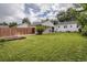 Spacious backyard featuring a lush lawn, wooden fence, and mature trees, perfect for outdoor activities at 2634 S Humboldt St, Denver, CO 80210