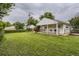 A backyard featuring lush green grass and a charming white house with a cozy front porch at 2634 S Humboldt St, Denver, CO 80210