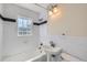 Bright bathroom with white subway tile and a window above the bath tub at 2634 S Humboldt St, Denver, CO 80210