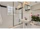 Charming bathroom featuring a shower over tub, stylish pedestal sink, and decorative black accent tiles at 2634 S Humboldt St, Denver, CO 80210