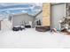 Snowy backyard with hot tub, grill, brick chimney, and patio, perfect for entertaining or relaxing at 1606 S Flanders Way, Aurora, CO 80017