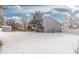 Large fenced backyard with mature trees and open space under a blanket of fresh snow at 1606 S Flanders Way, Aurora, CO 80017