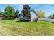 A large backyard featuring mature trees, a healthy green lawn and a partial fence at 1606 S Flanders Way, Aurora, CO 80017
