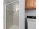 Shower stall with glass doors and tiled walls next to the laundry machines at 1606 S Flanders Way, Aurora, CO 80017