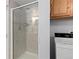 Bathroom with a shower featuring glass doors and a laundry area with a washing machine at 1606 S Flanders Way, Aurora, CO 80017