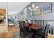 Open-concept dining area with a large table, hardwood floors, gray walls, and stylish light fixtures, ideal for gatherings at 1606 S Flanders Way, Aurora, CO 80017