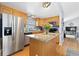 Well-lit kitchen featuring an island, stainless steel appliances, wooden cabinets, and hardwood floors for a functional layout at 1606 S Flanders Way, Aurora, CO 80017