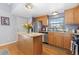 Bright kitchen with granite countertops, stainless steel appliances, wood cabinetry, and a center island at 1606 S Flanders Way, Aurora, CO 80017