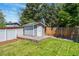 Backyard shed with a blue exterior, white door, and concrete foundation surrounded by grass at 1606 S Flanders Way, Aurora, CO 80017
