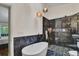 Elegant bathroom with standalone tub, modern lighting, and a stylish black tiled shower at 8747 Mesquite Row, Lone Tree, CO 80124