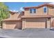 Exterior view of townhome featuring a two car garage and red tiled roof at 8747 Mesquite Row, Lone Tree, CO 80124